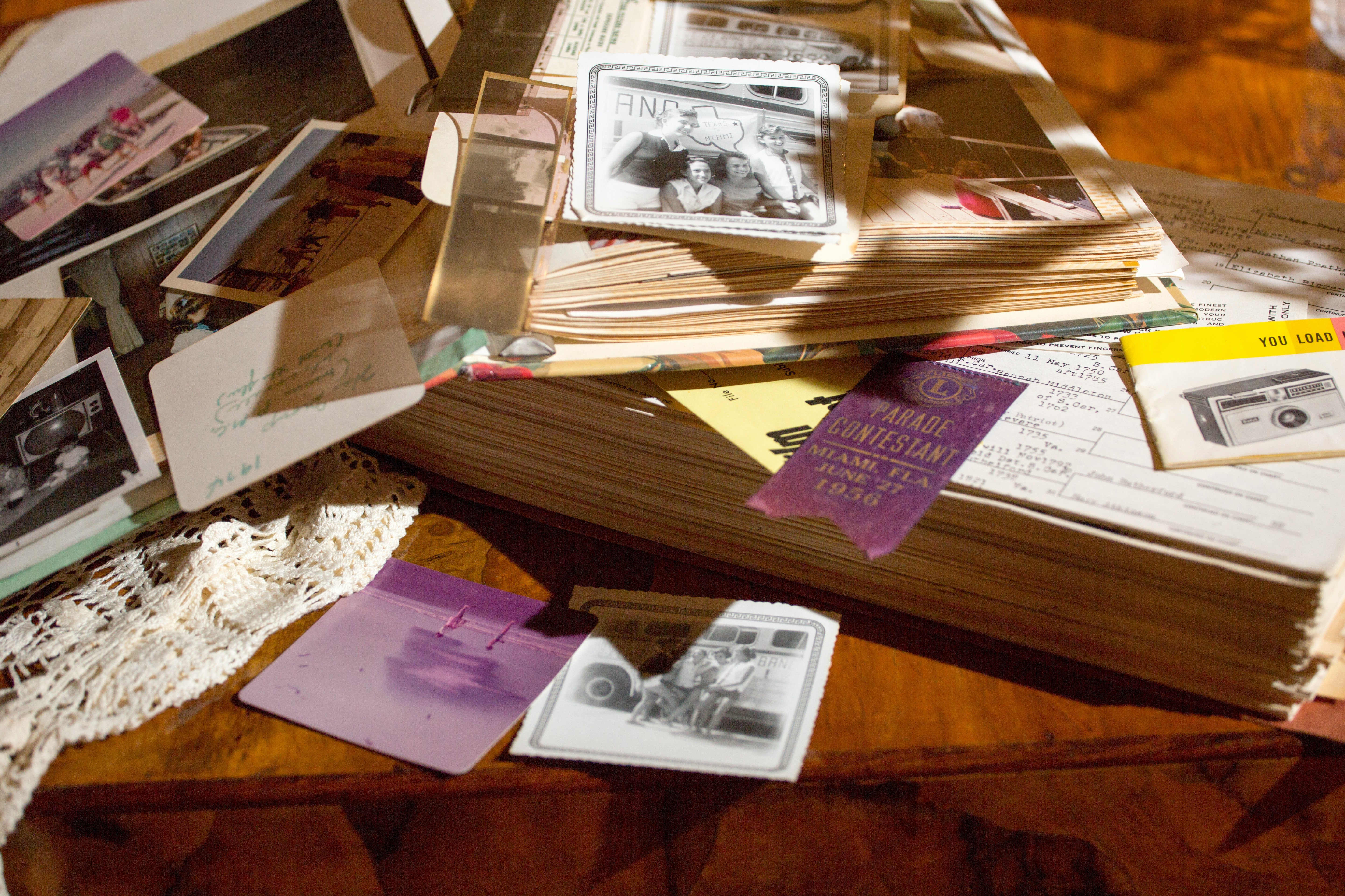Old photographs and papers spread across a table — a life remembered